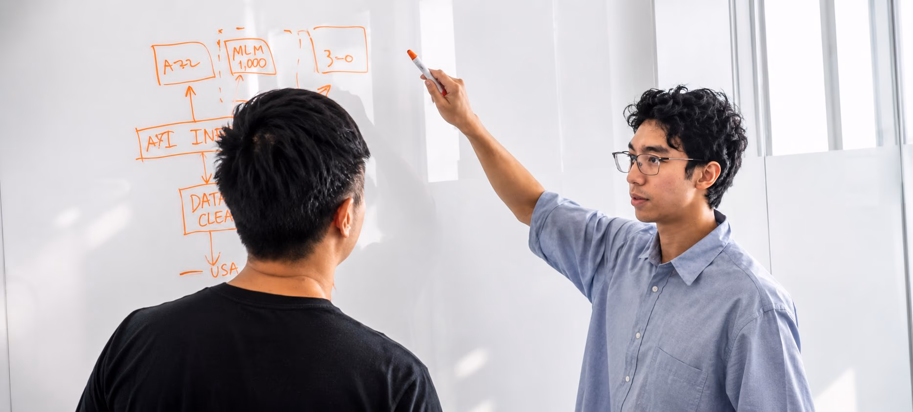An engineer sketching an AI pipeline on a whiteboard during a ChipAgents training session
